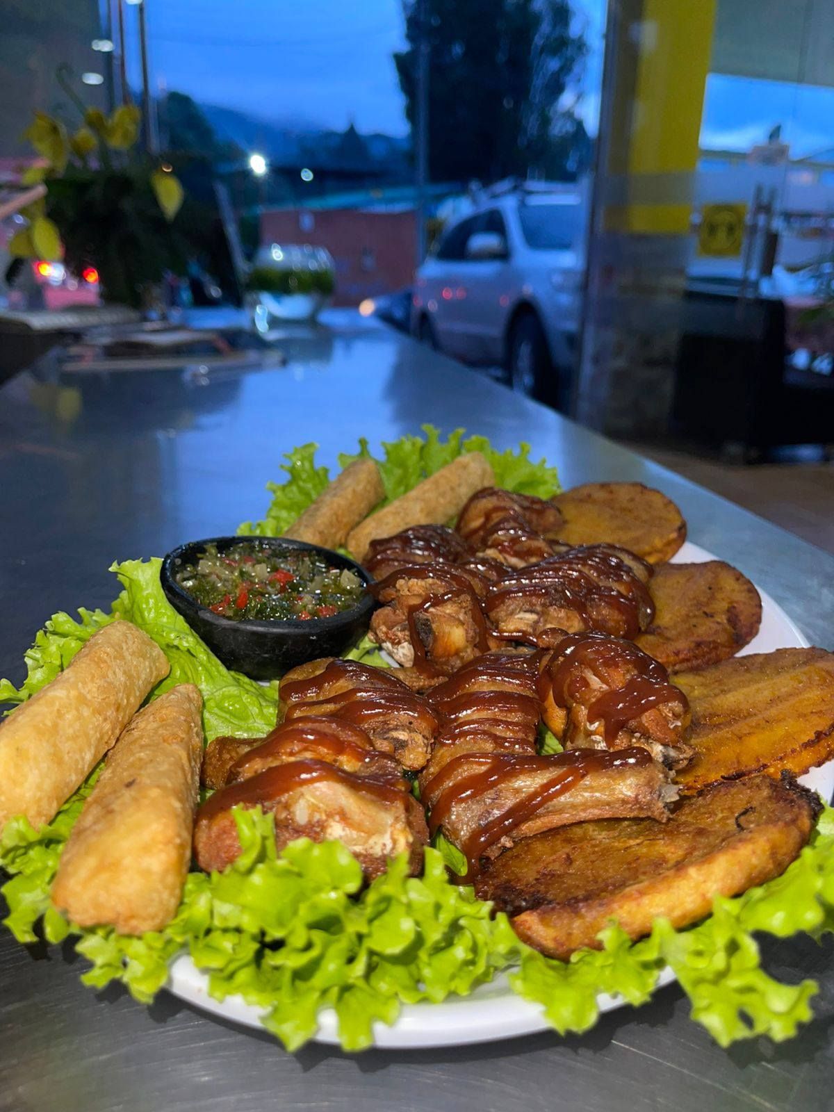 Mano en guante amarillo rociando limpiador desde una botella transparente.