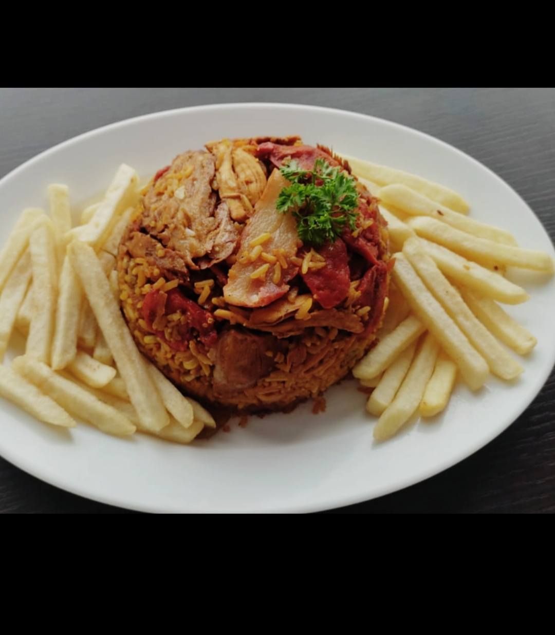 Una mano enguantada pasa un paño rojo por el capó blanco de un coche, cerca de un faro brillante.