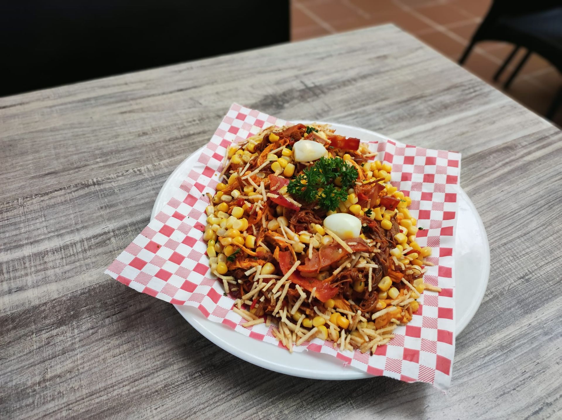 Persona con traje de materiales peligrosos rociando una barandilla de metal con un rociador al aire libre.