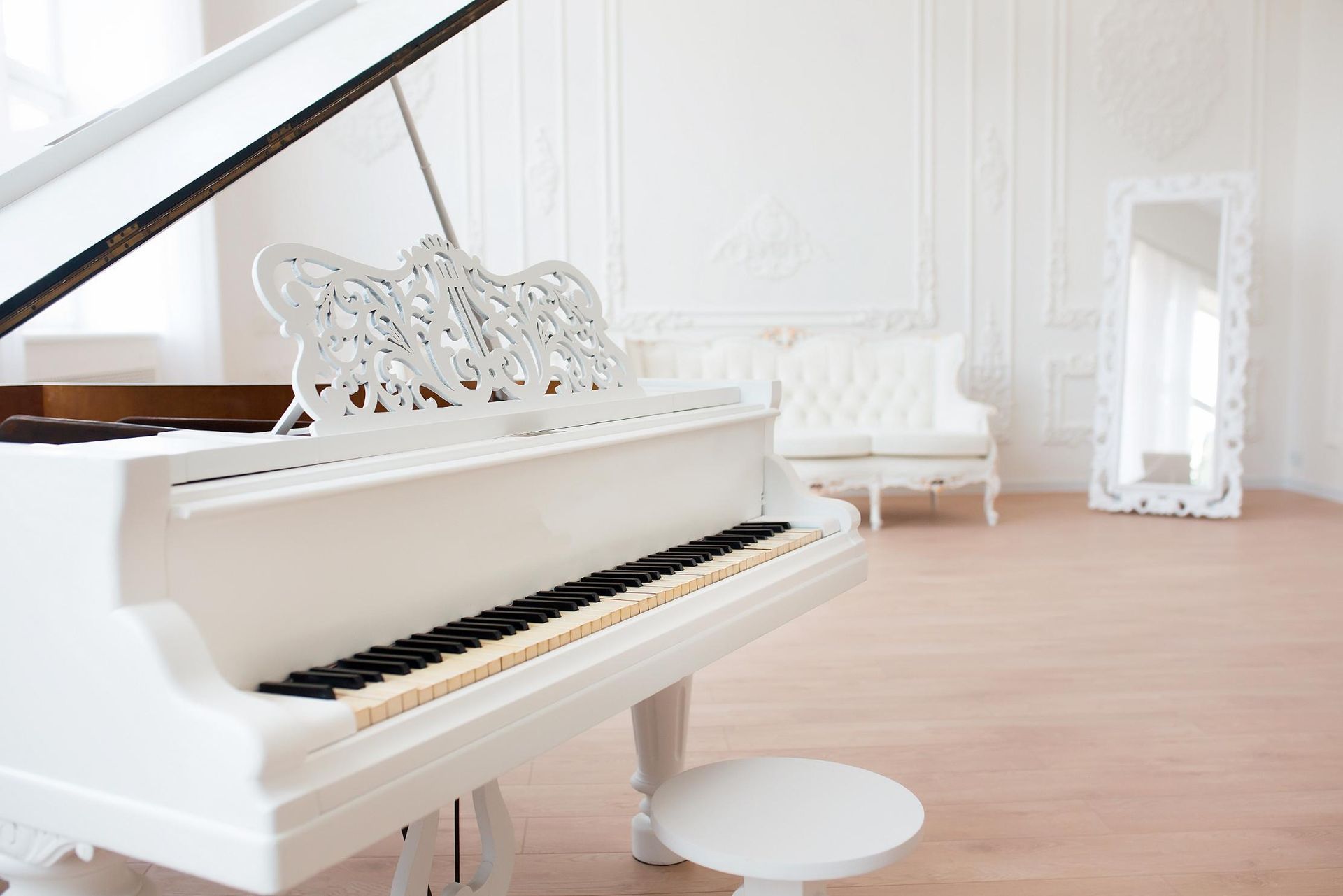 A white grand piano is sitting in a living room.