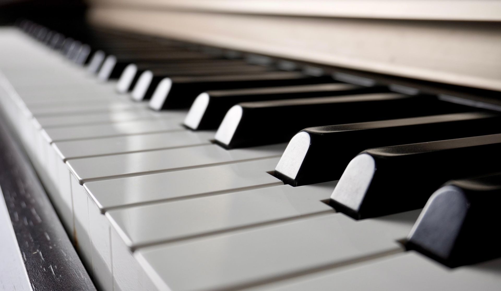 A close up of a piano keyboard with black and white keys.