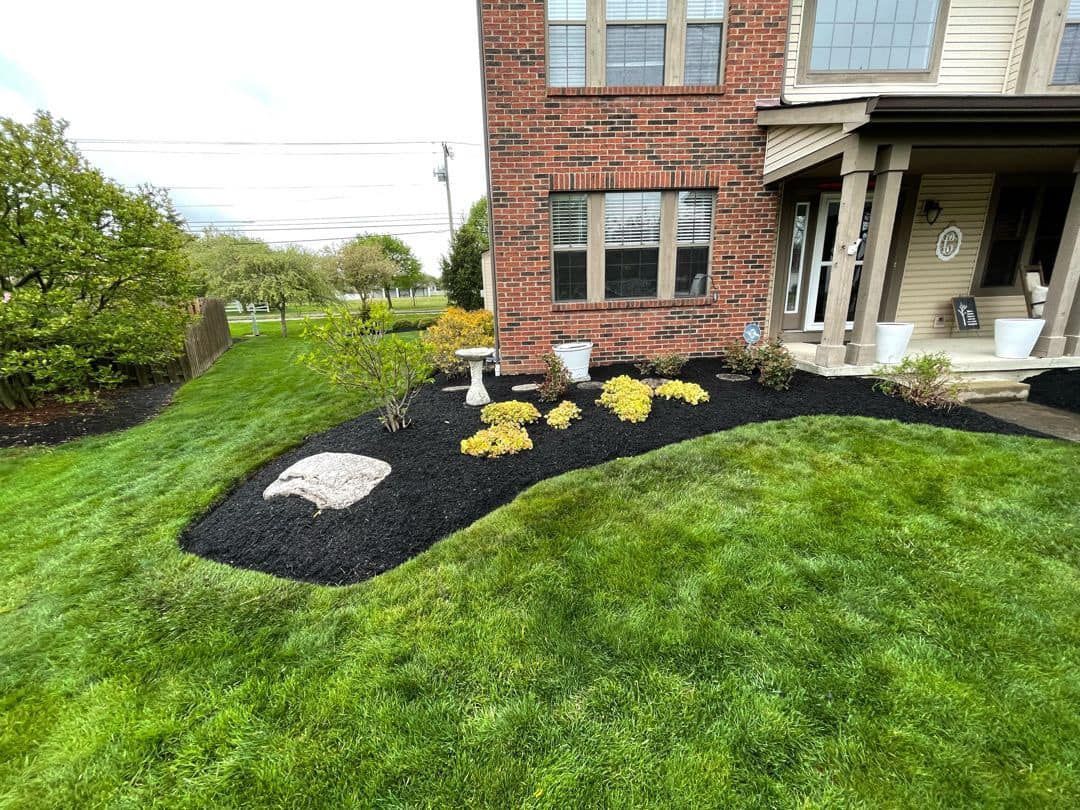 A large brick house with a lush green lawn in front of it.