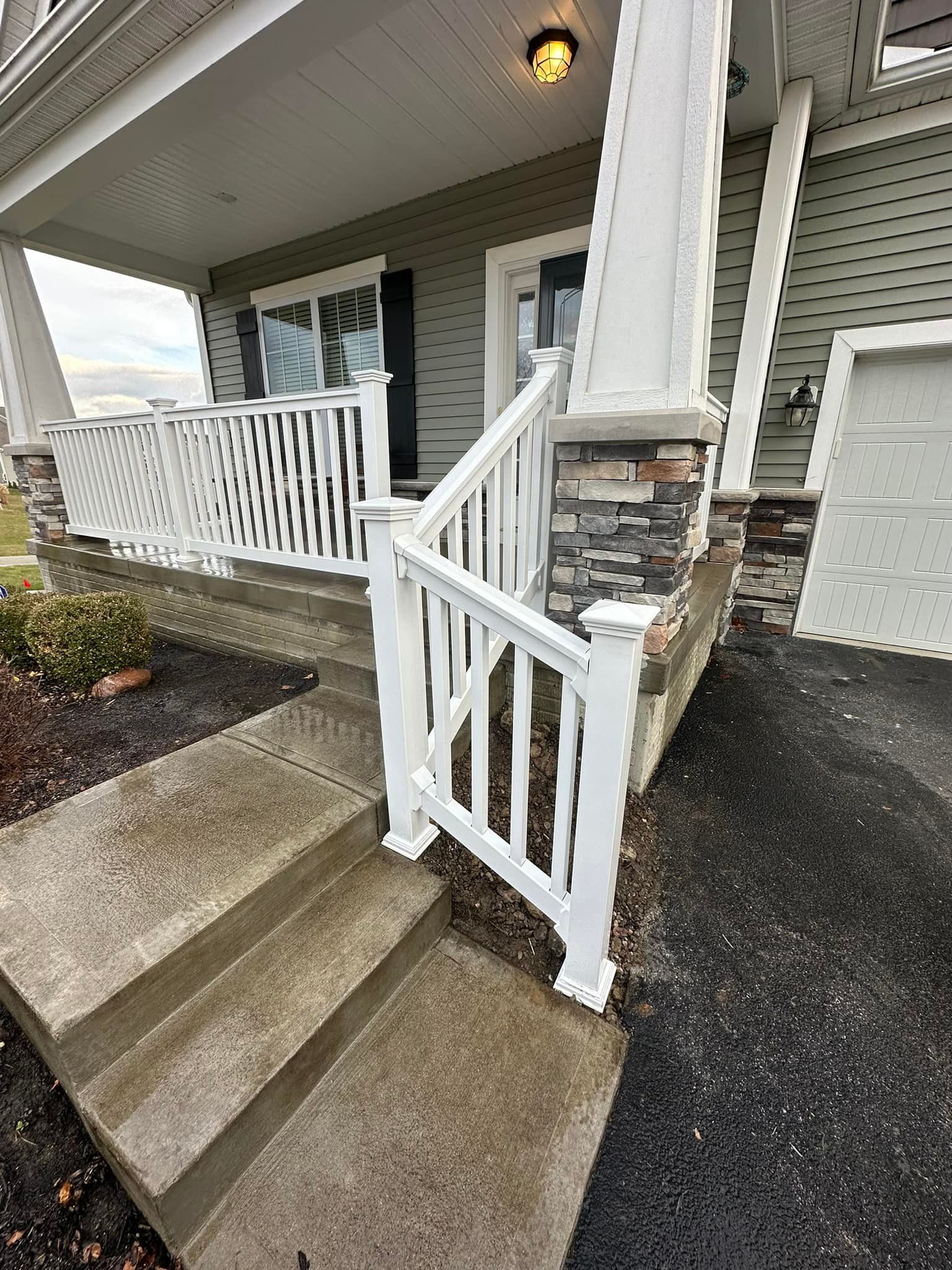 There is a white railing on the porch of a house.