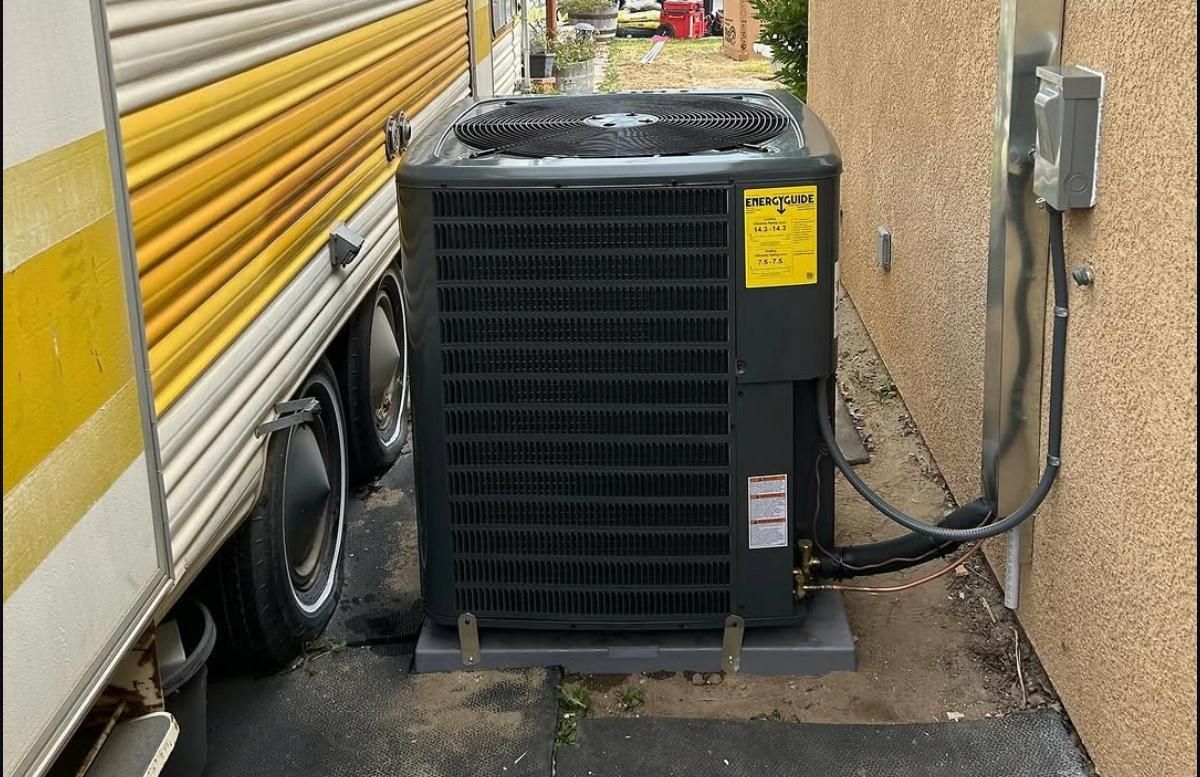 Outdoor HVAC unit beside a building, with yellow pipes running along the wall.