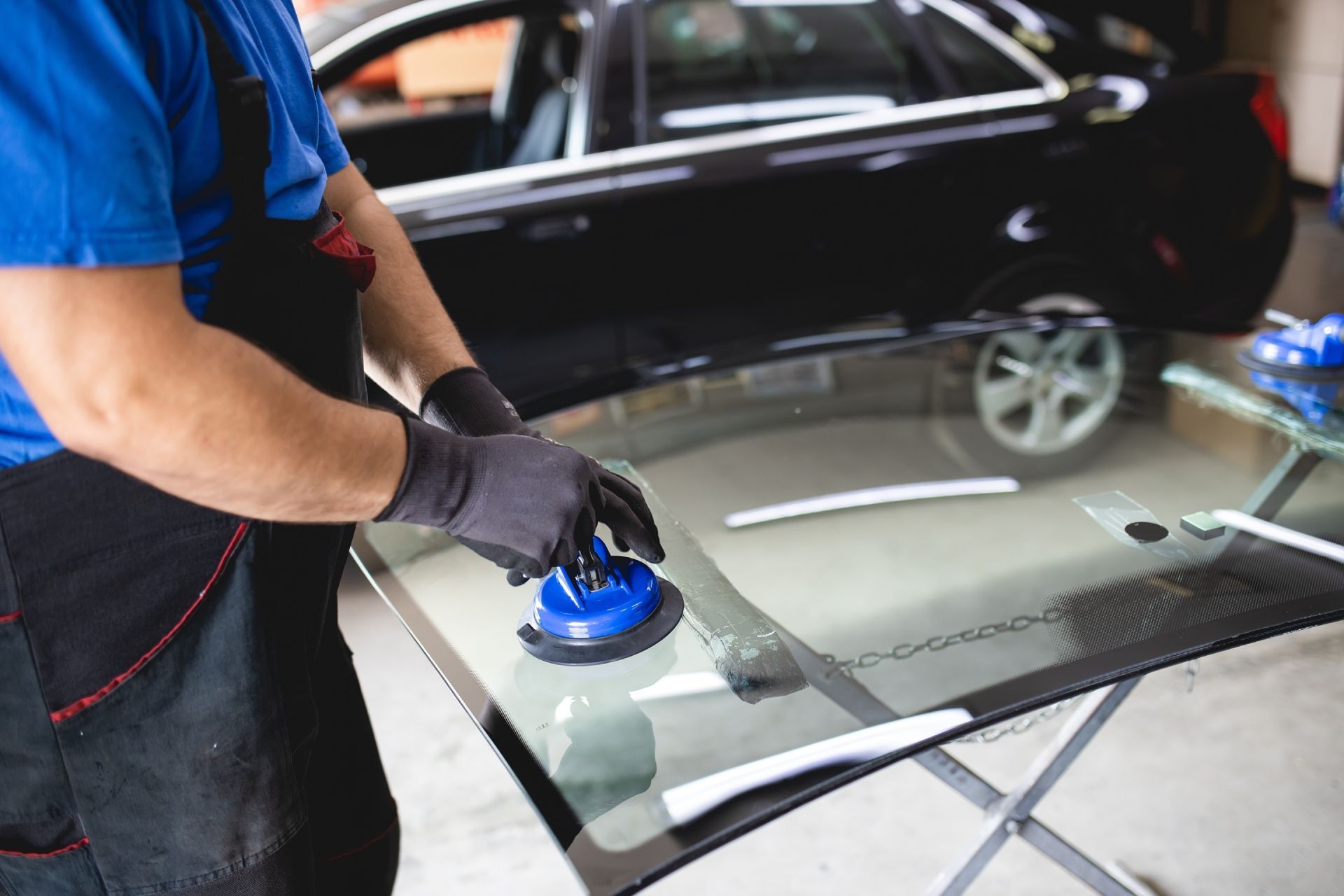 A man is installing a windshield on a car.