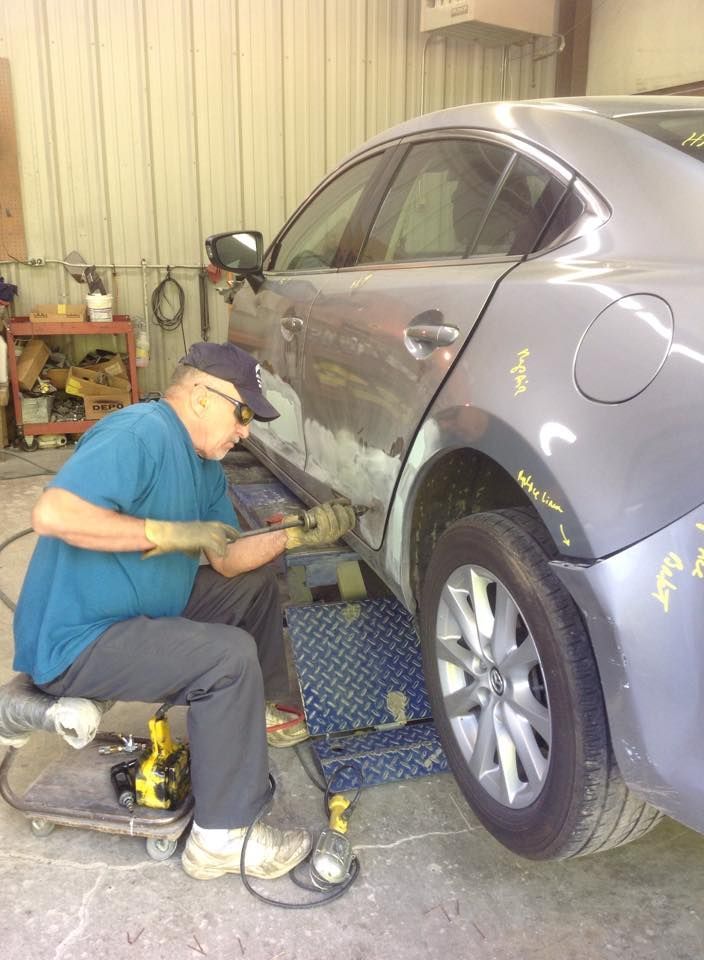 A man is working on a car in a garage