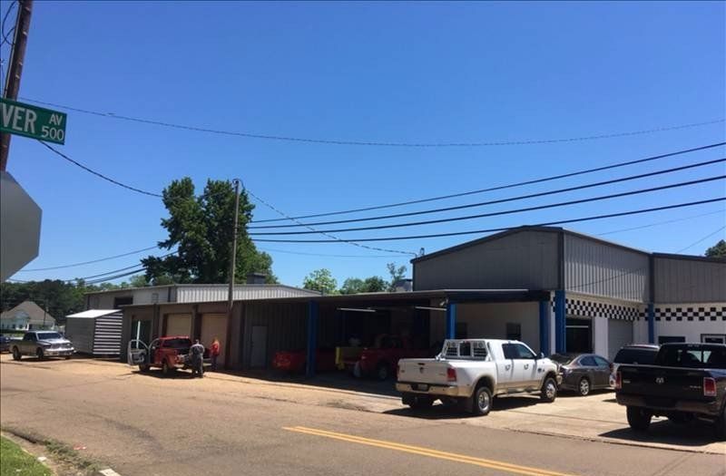A truck is parked in front of a building with a green street sign