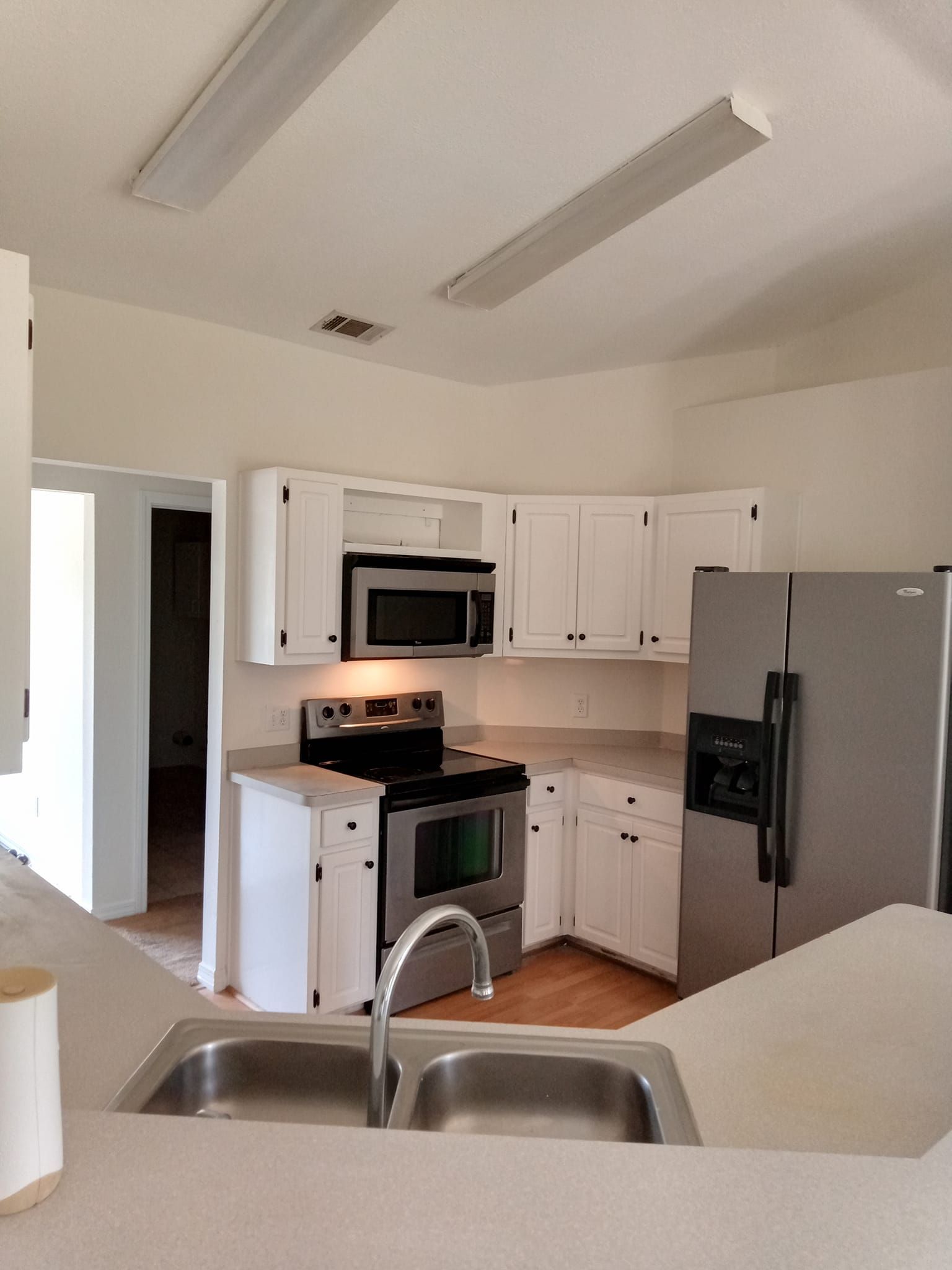 A kitchen with stainless steel appliances and white cabinets