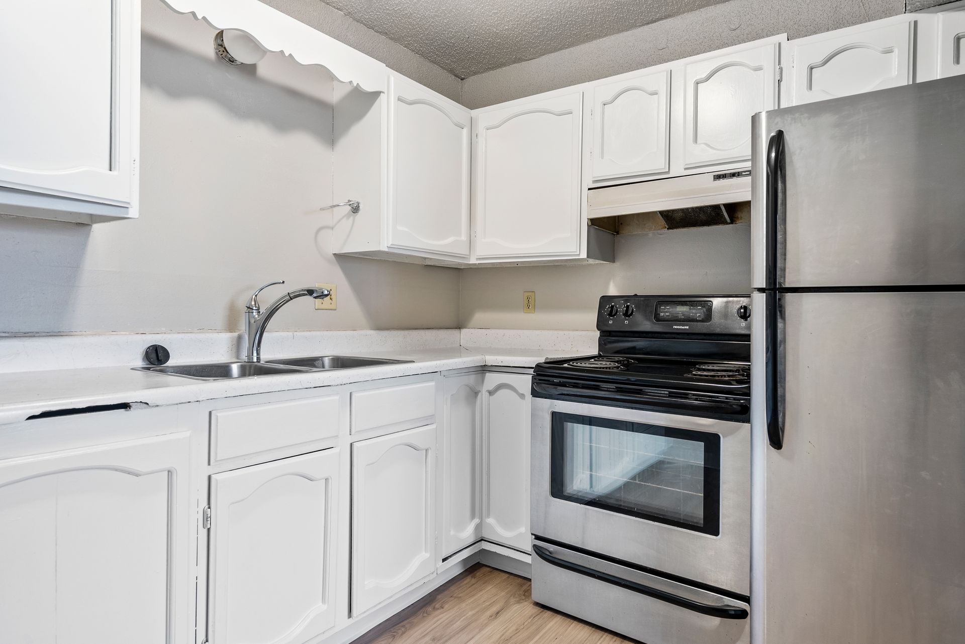 photo of sink area, refrigerator and stove