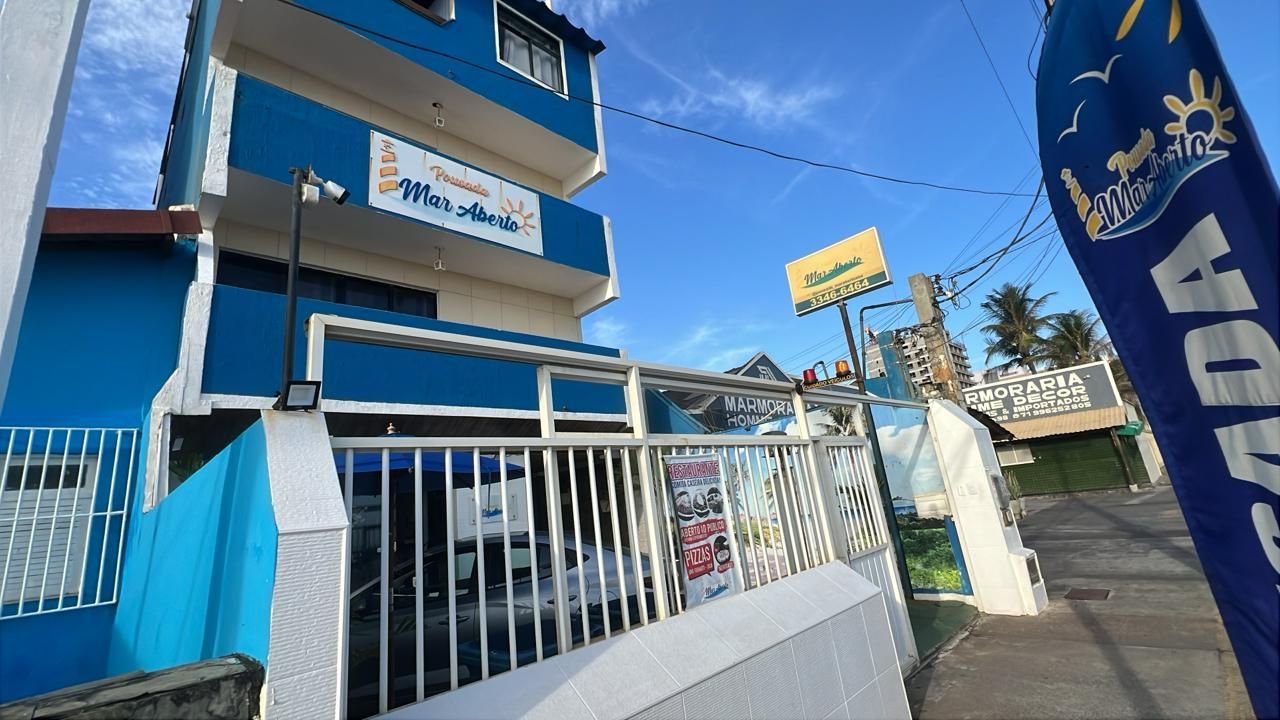 Prédio azul com placas indicando "Tourismo Varadero" e uma bandeira listrada em azul e branco.