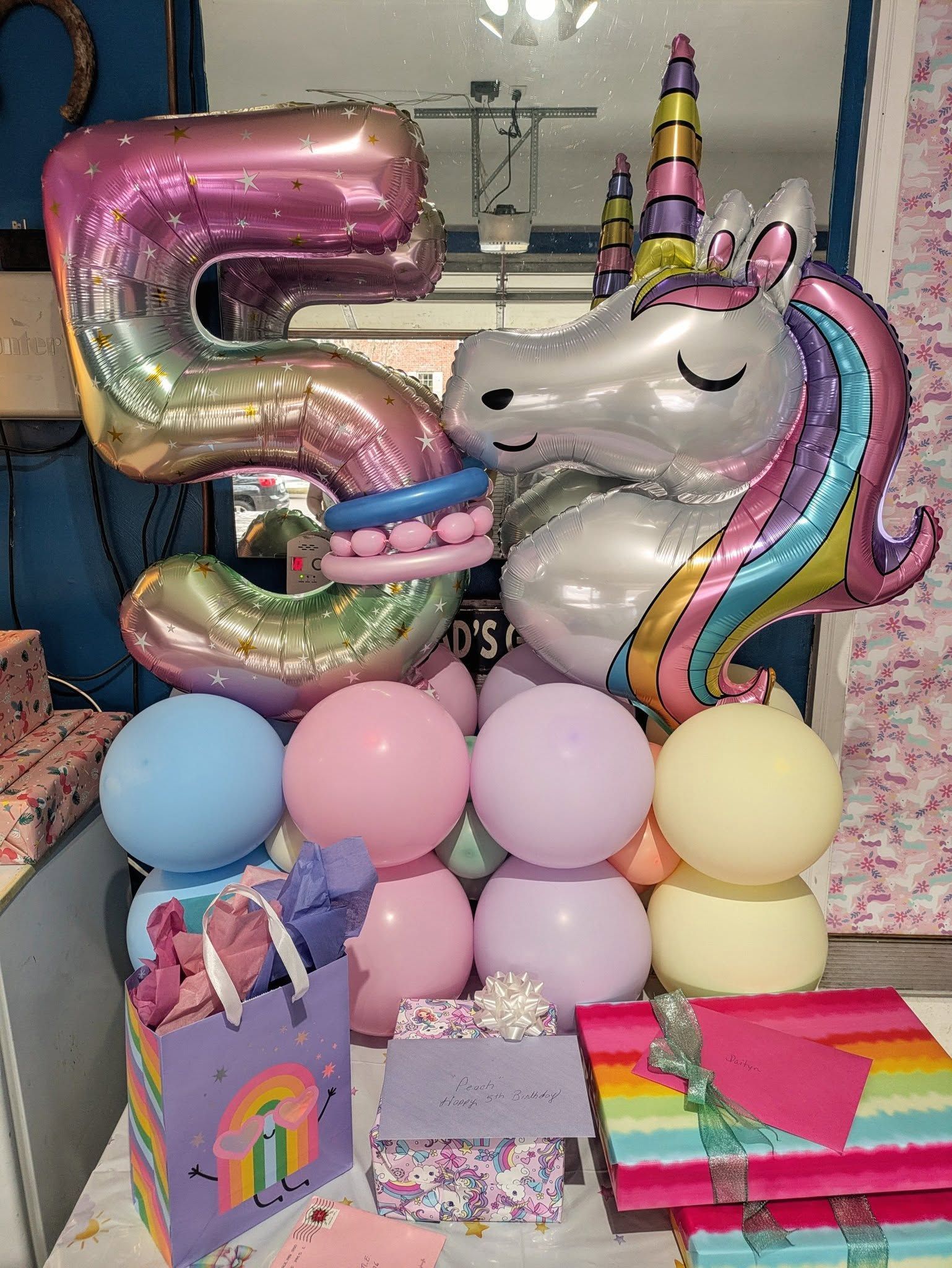 A table topped with balloons and a unicorn balloon.