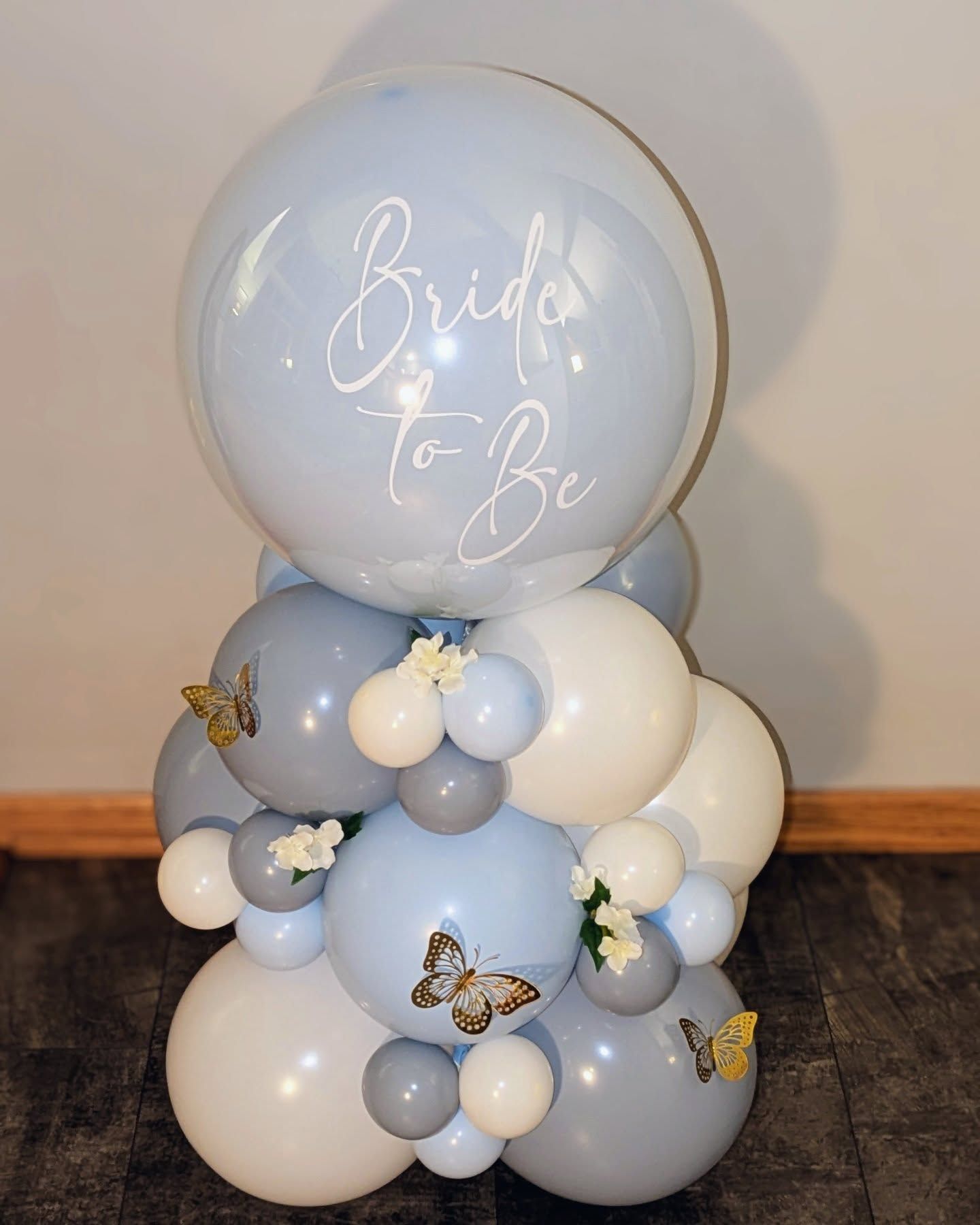 A bride to be balloon is surrounded by blue and white balloons.