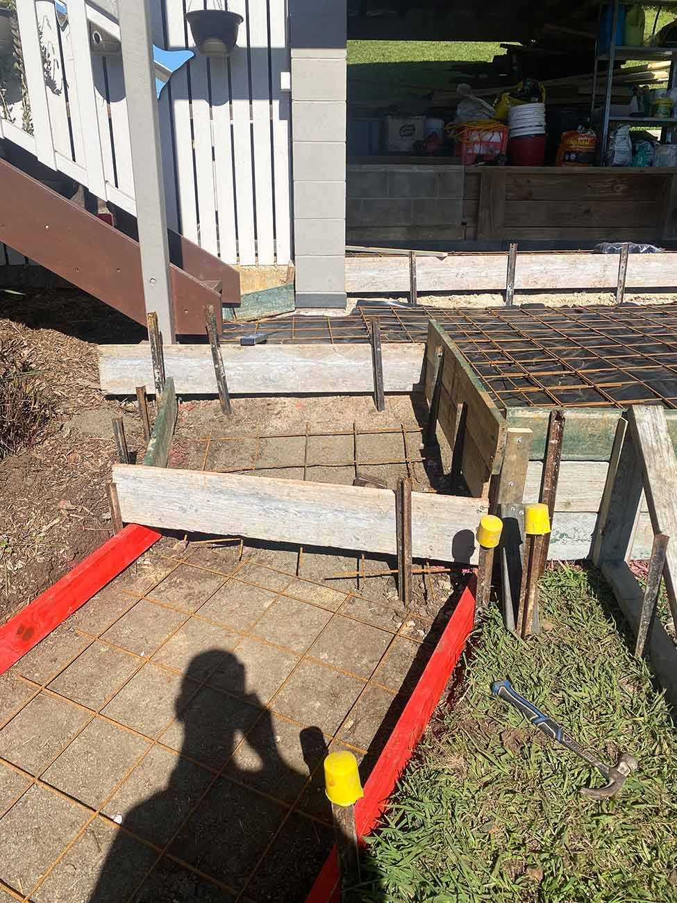 A Shadow of A Person Is Cast on A Concrete Walkway — Shaka Concreting In South Golden Beach, NSW
