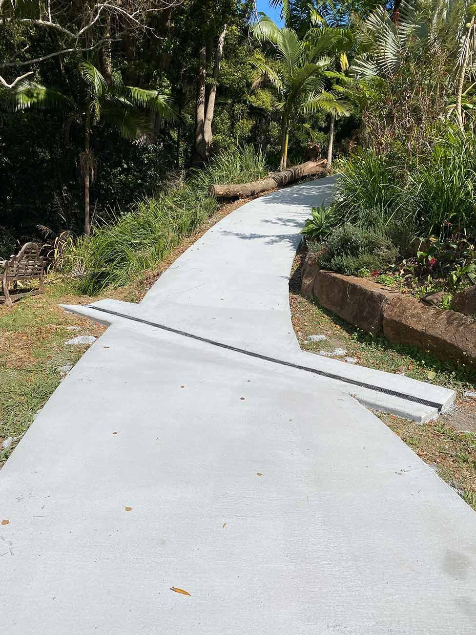 A Concrete Walkway Going Through a Lush Green Forest — Shaka Concreting In South Golden Beach, NSW