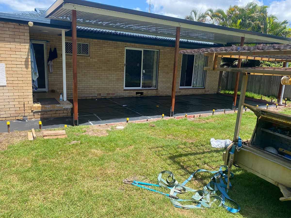 A Brick House with A Covered Porch and A Trailer Parked in Front of It — Shaka Concreting In South Golden Beach, NSW