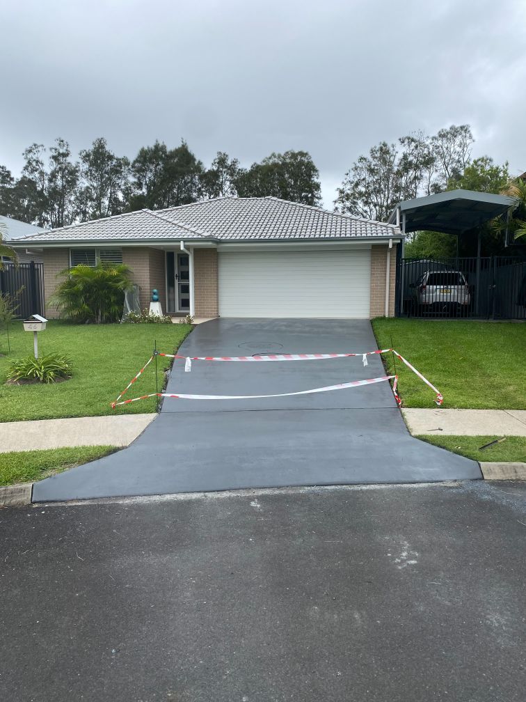 A Fresh Concrete Driveway With Caution Tape in Front — Shaka Concreting In South Golden Beach, NSW