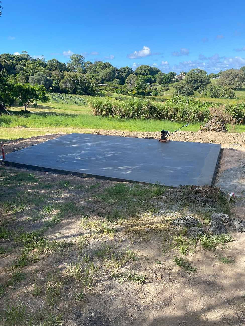 A Large Concrete Slab Is Sitting in The Middle of A Dirt Field — Shaka Concreting In South Golden Beach, NSW