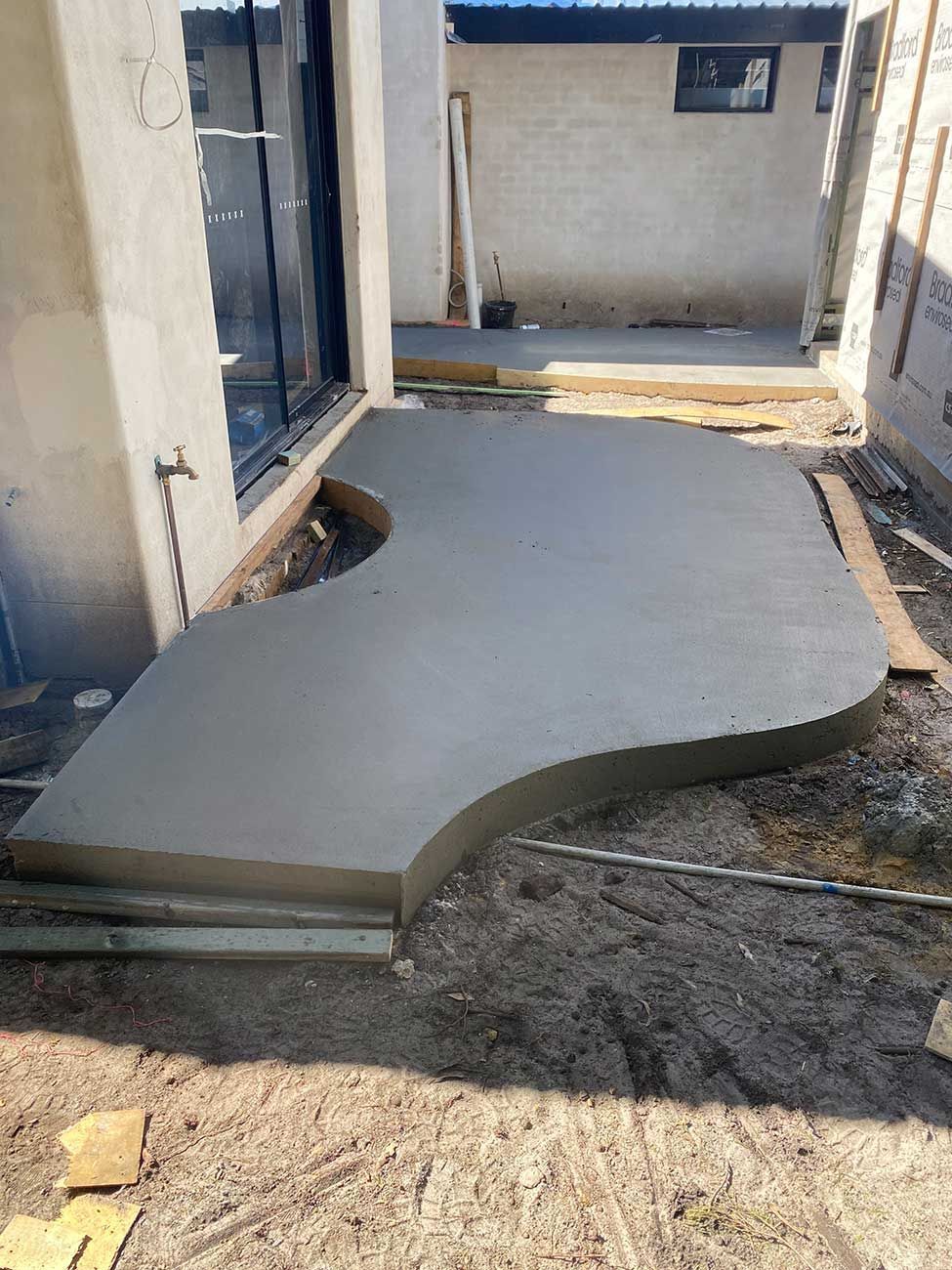A Concrete Walkway Is Being Built in Front of A House — Shaka Concreting In South Golden Beach, NSW