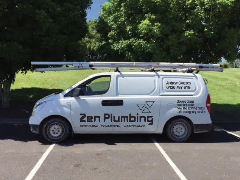 White Zen Plumbing van with ladder parked in a parking space on a sunny day.