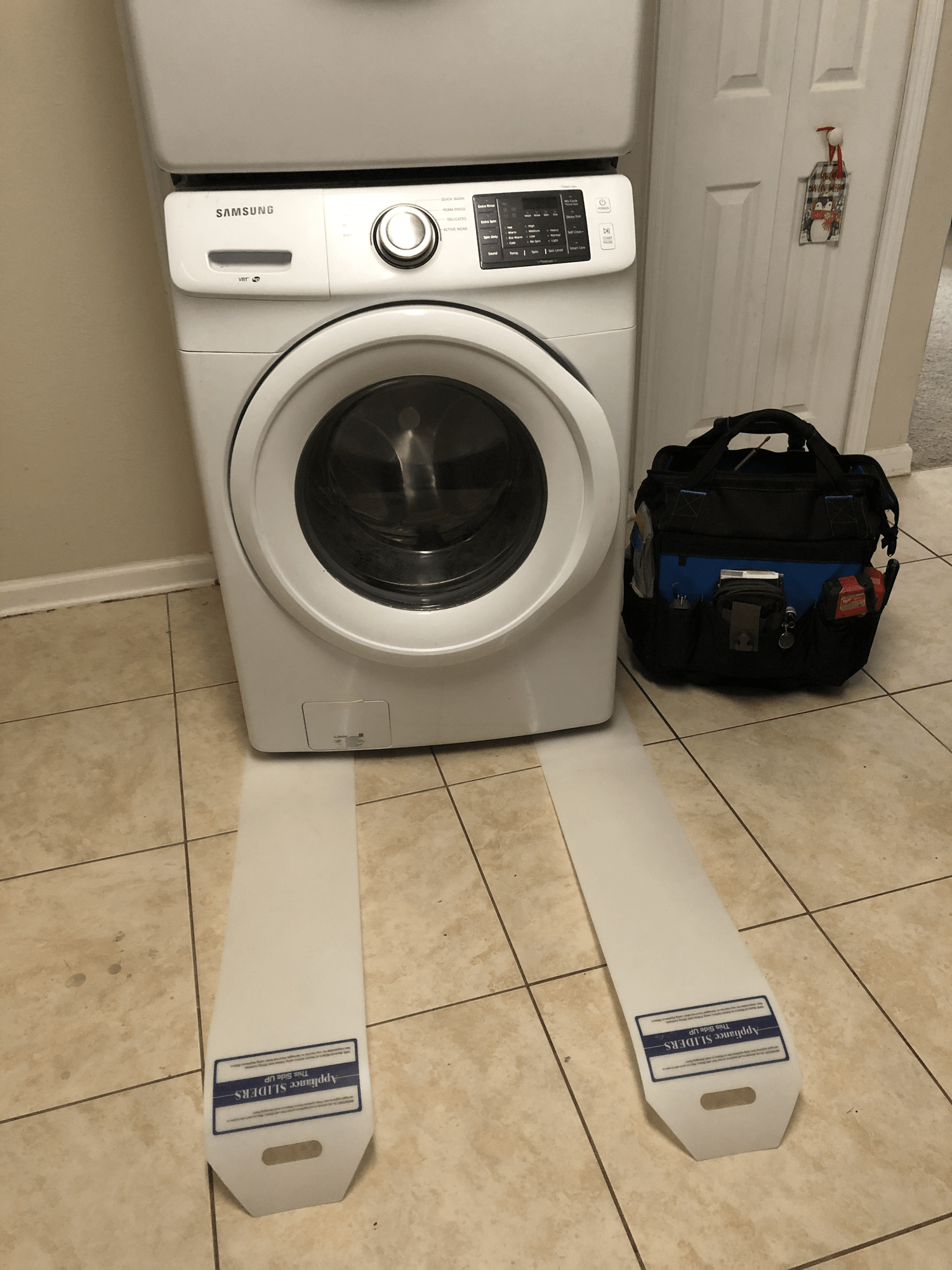 A washer and dryer are stacked on top of each other in a laundry room.