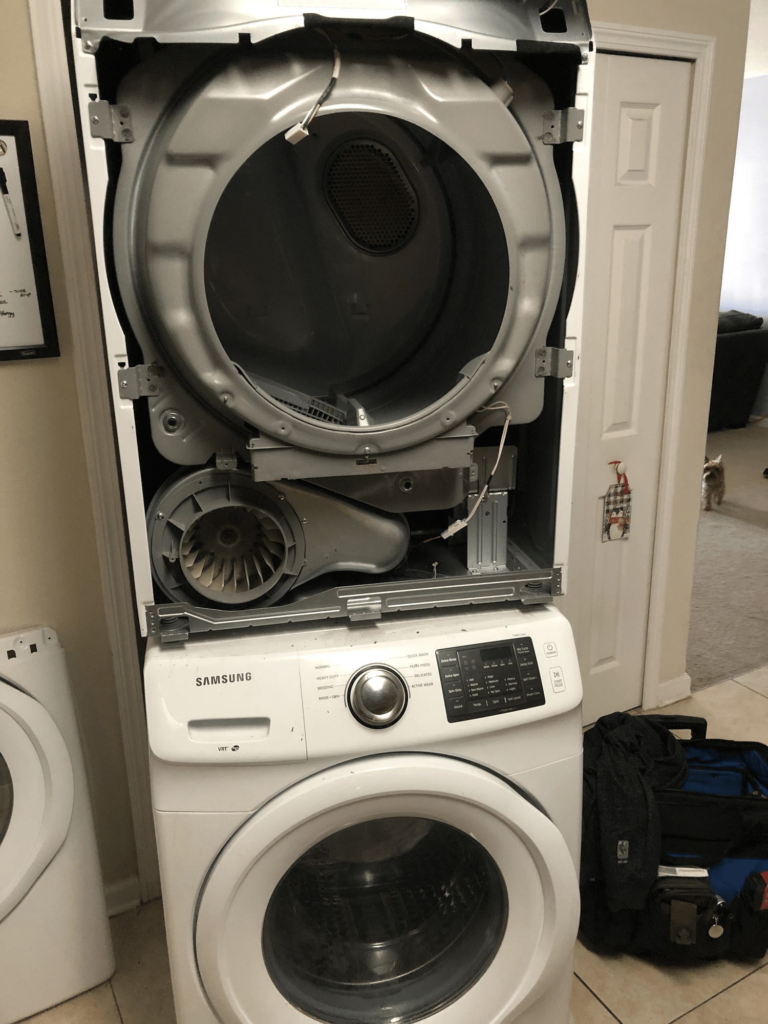 A washer and dryer are stacked on top of each other in a room.
