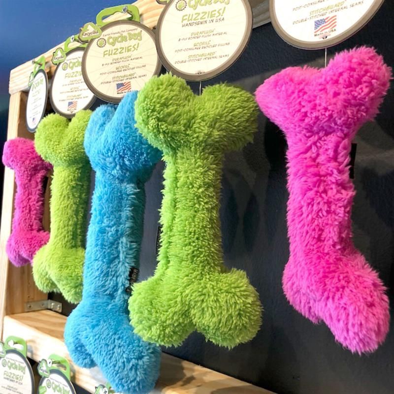 A bunch of stuffed bones are lined up on a shelf