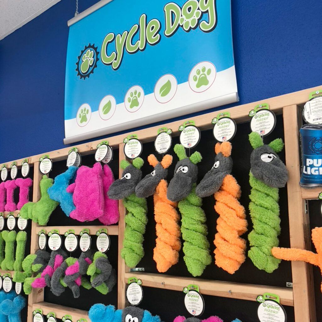 A bunch of stuffed animals are on display under a sign that says cycle dog