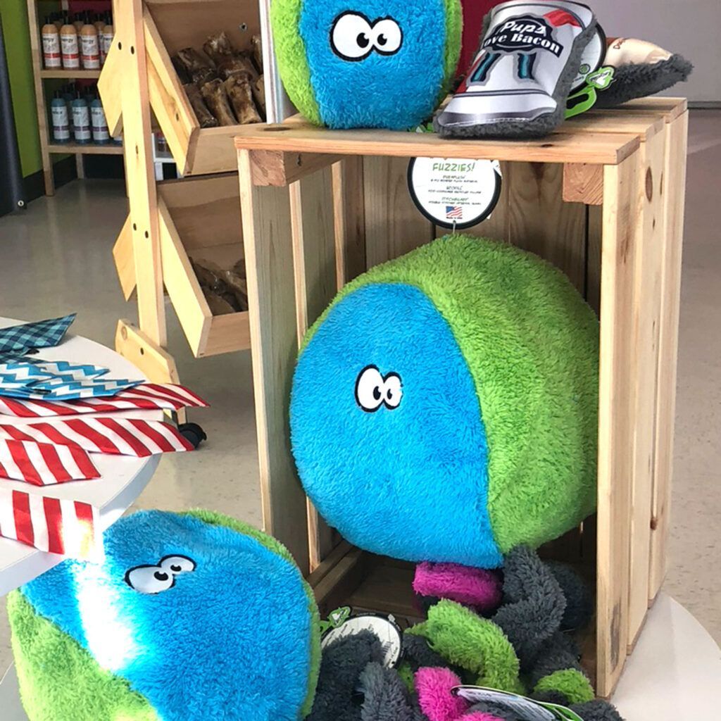 A bunch of stuffed animals are sitting on top of a wooden crate.