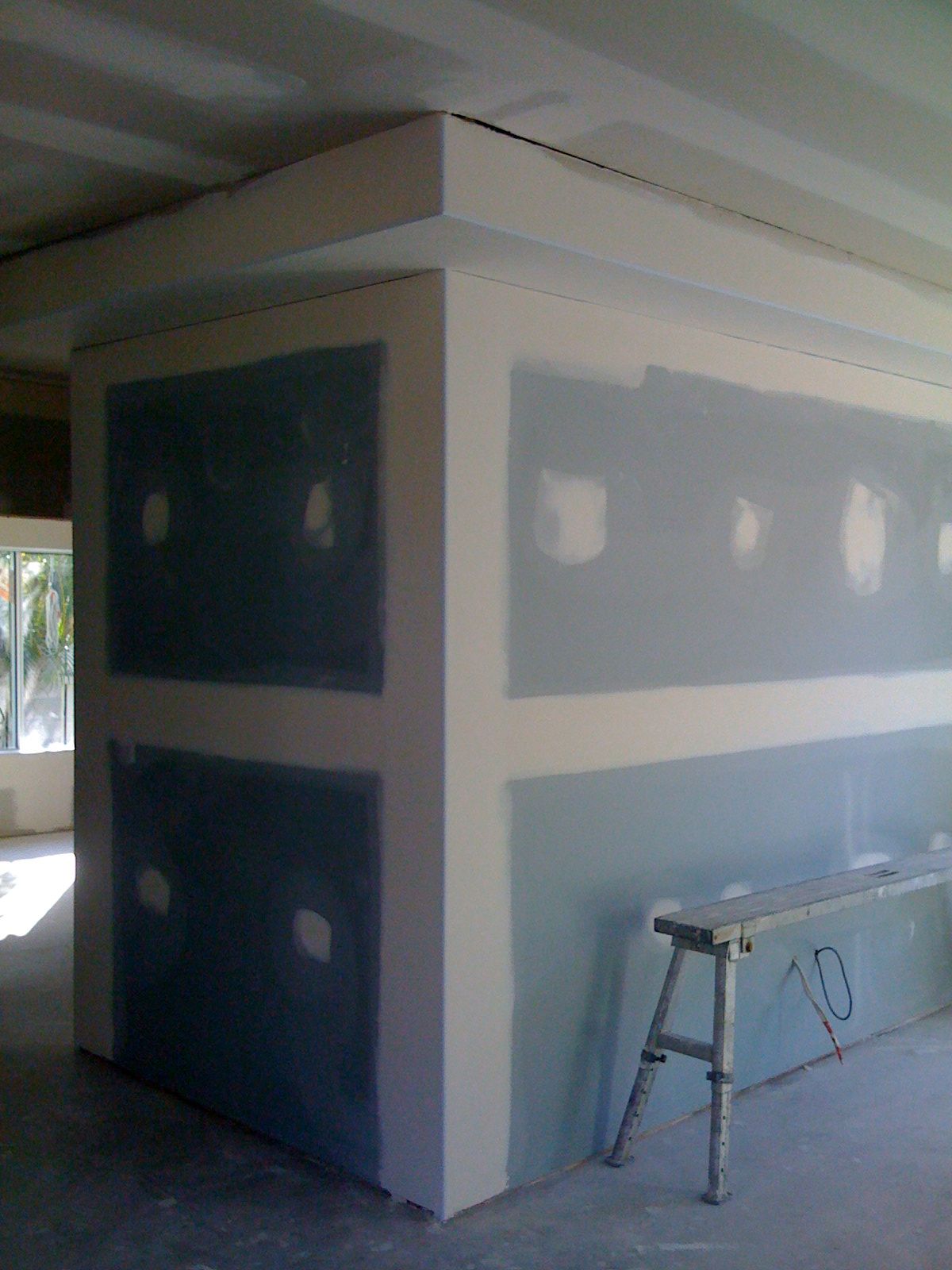 Unfinished Room with Drywall Patches and A Step Ladder Beside a Wall Opening — SS Building Services in Townsville, QLD