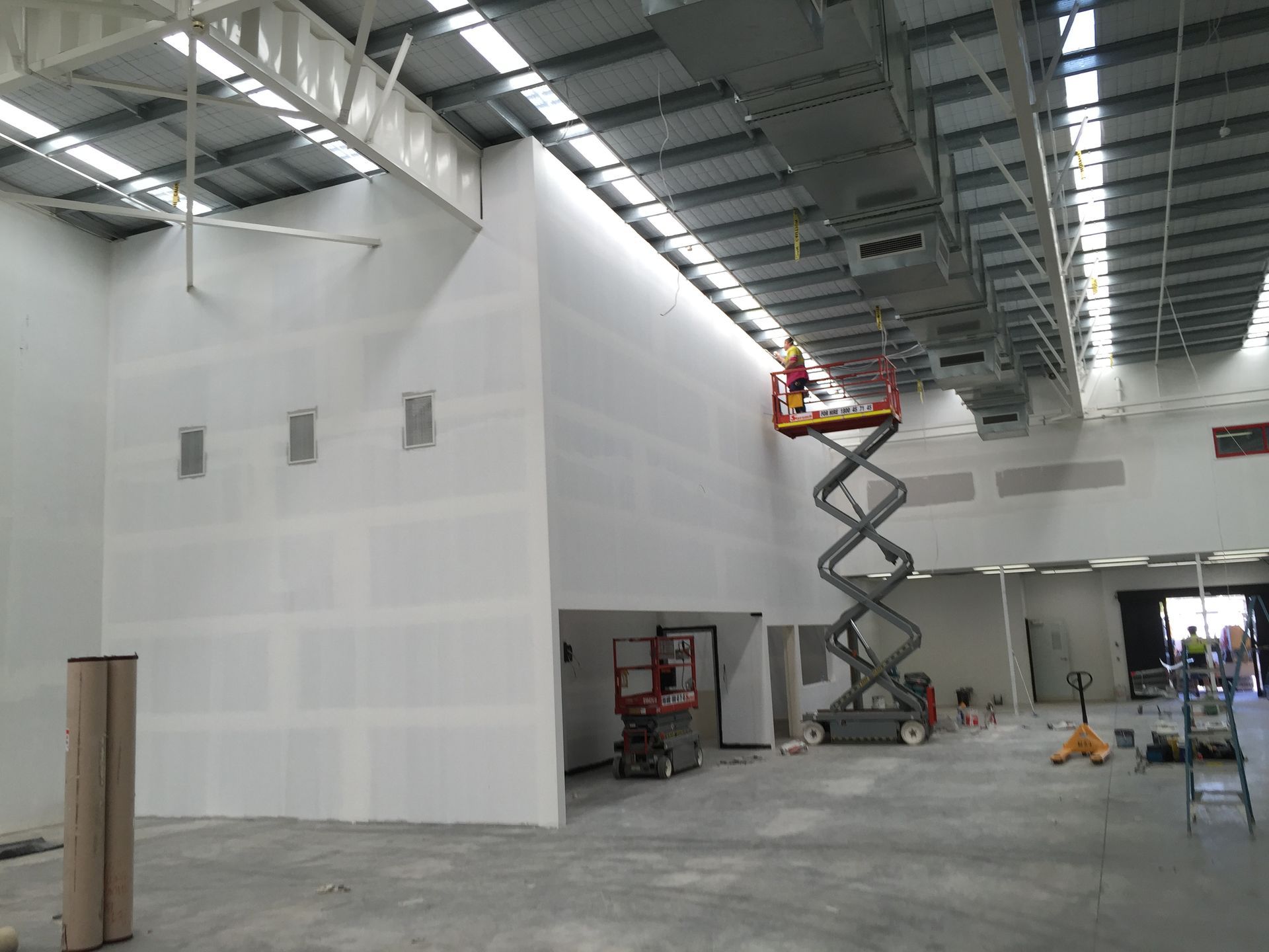 Large Indoor Warehouse Under Construction with White Drywall — SS Building Services in Townsville, QLD