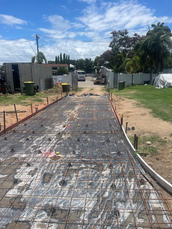 A Concrete Driveway is Being Built in a Residential Area — Shaun Steenson Building Services in Townsville, QLD