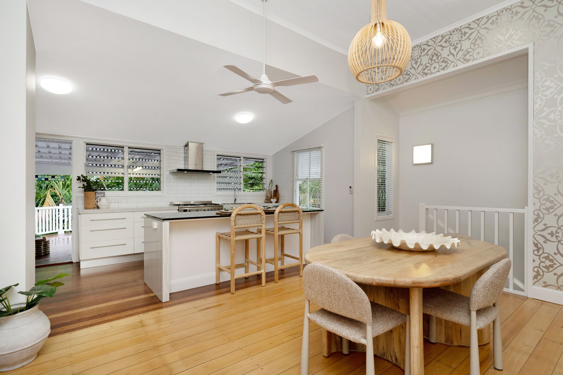 Bright Open Kitchen and Dining Area with White Cabinets — SS Building Services in Townsville, QLD
