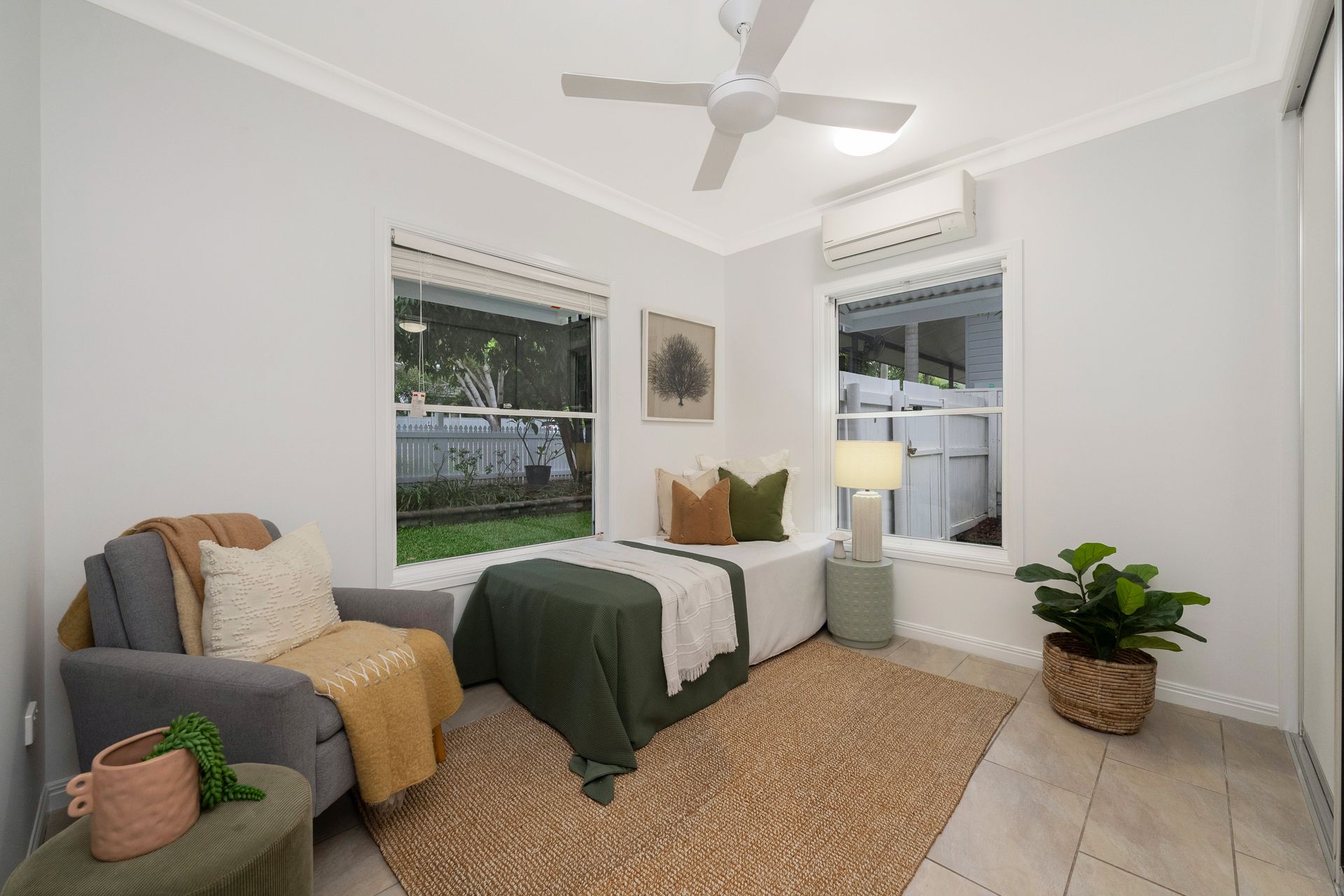Bright Bedroom with Twin Beds and A Potted Plant on The Floor — SS Building Services in Townsville, QLD