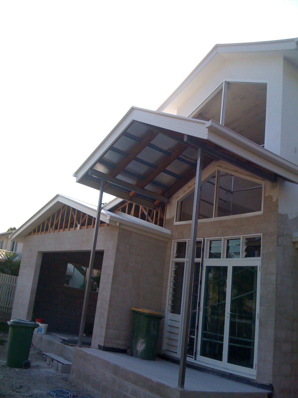 Modern Building Entrance with Glass Doors and A Metal Awning Over the Walkway — SS Building Services in Townsville, QLD