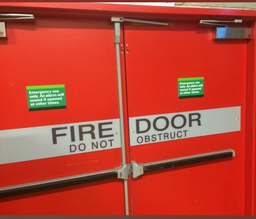 A Man is Using a Drill to Install a Door Lock — Shaun Steenson Building Services in Townsville, QLD