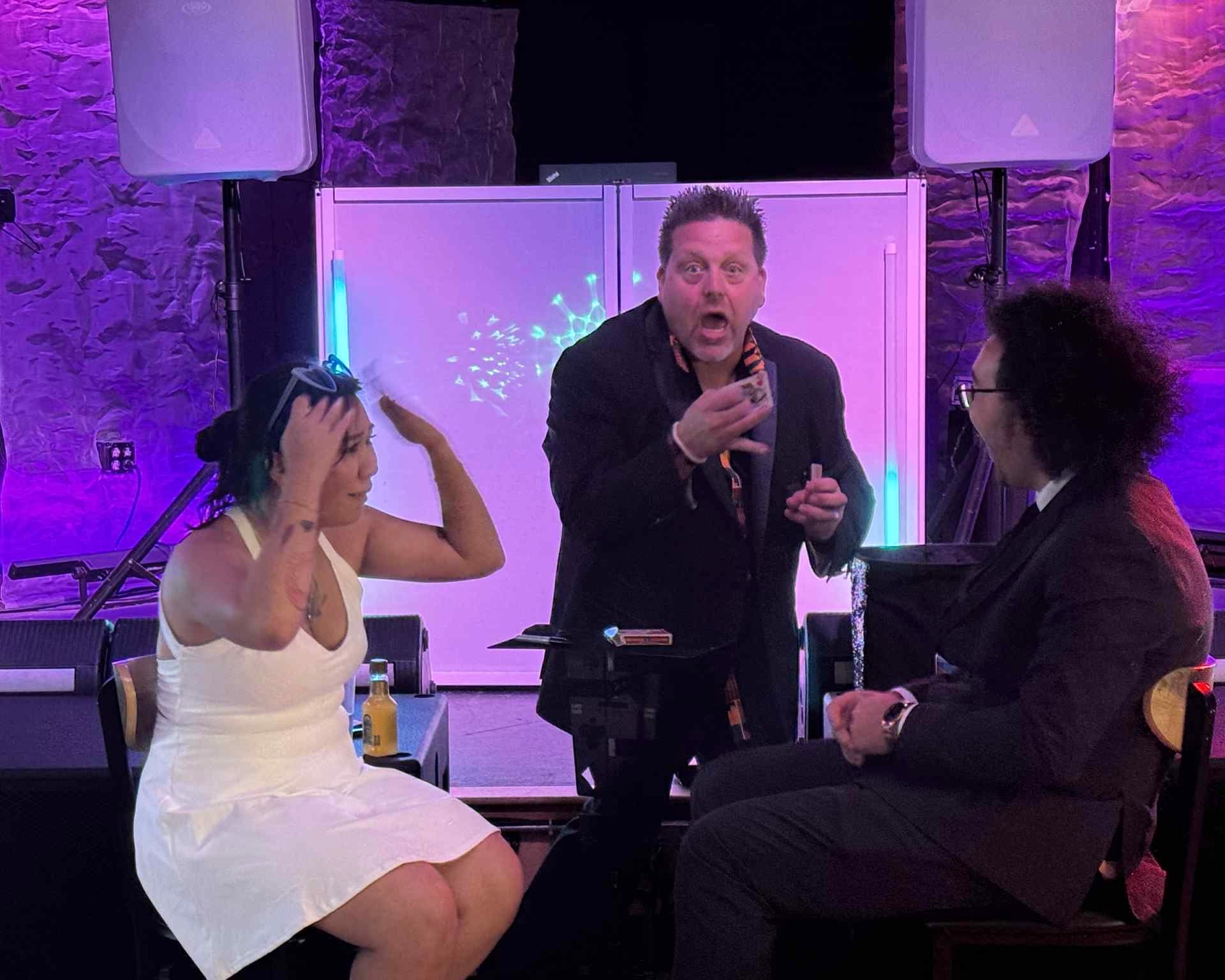 A group of people are sitting in a theater applauding.