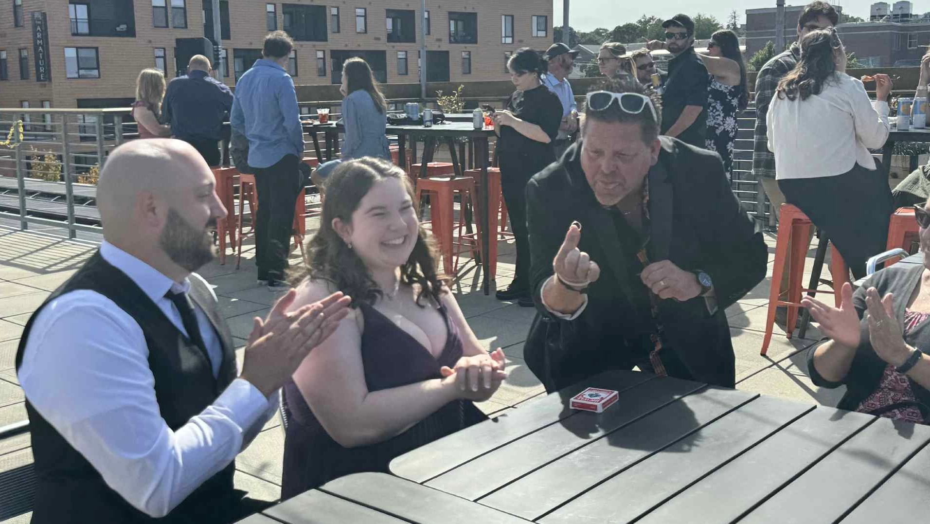 A group of people are clapping their hands together while sitting on a couch.