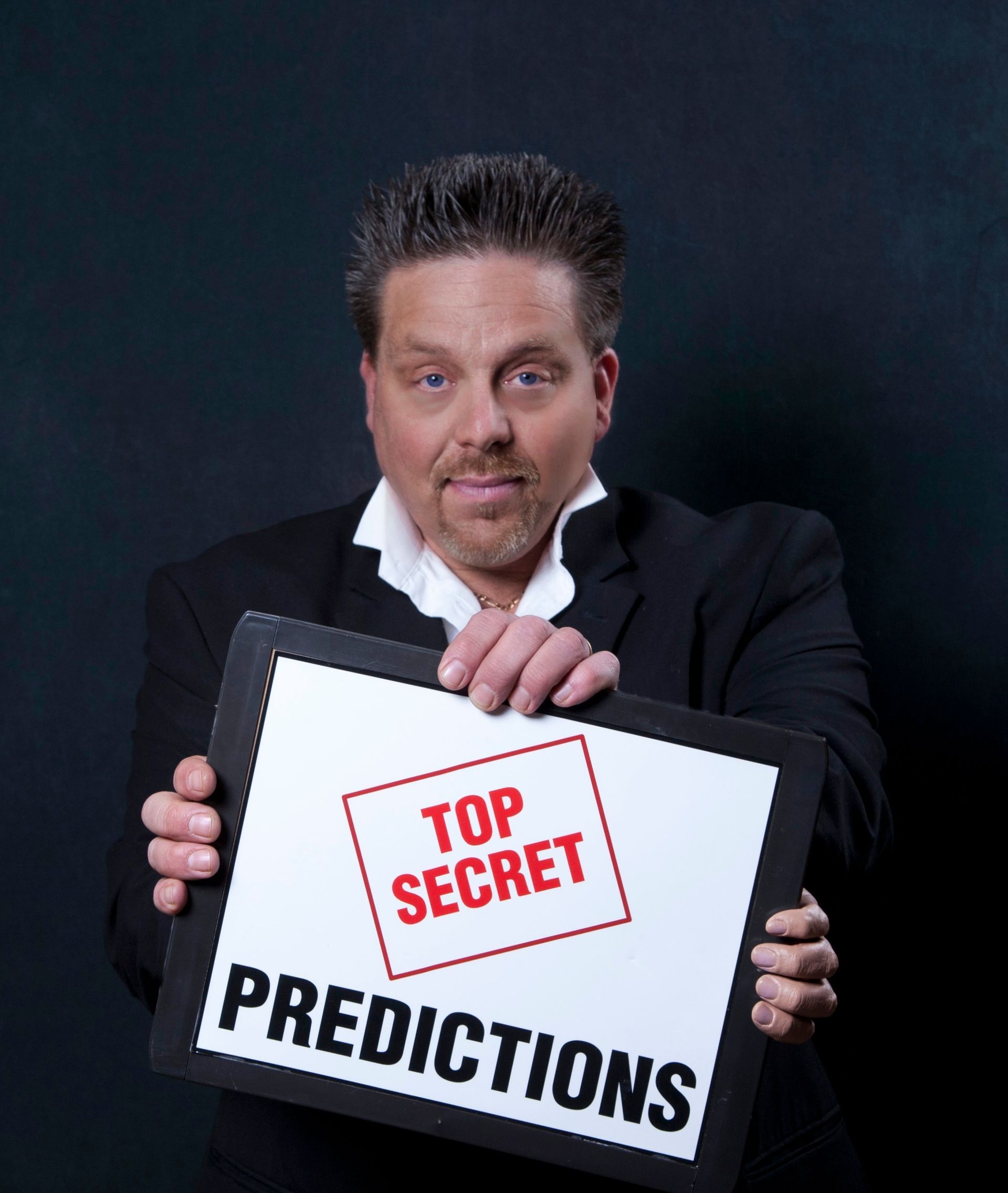 A man is holding a sign that says top secret predictions