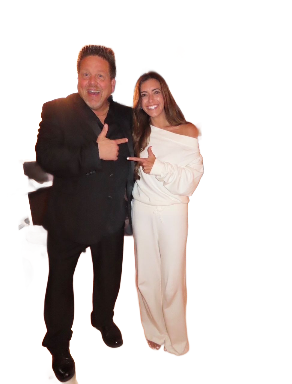 Two people posing indoors, smiling and pointing at each other in front of chairs and a “Camp Haley” banner.