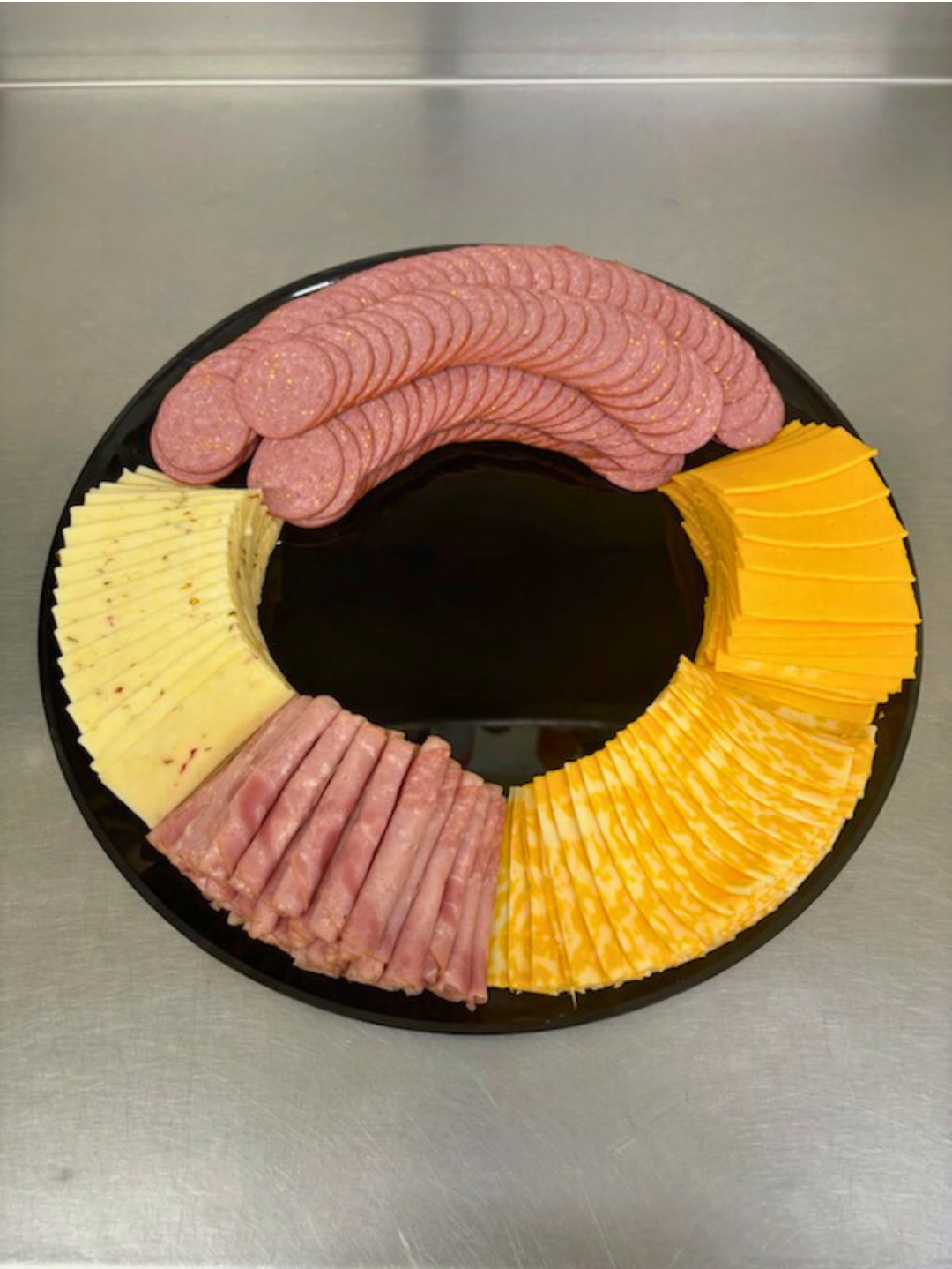 A plate of fruit and vegetables on a wooden table.