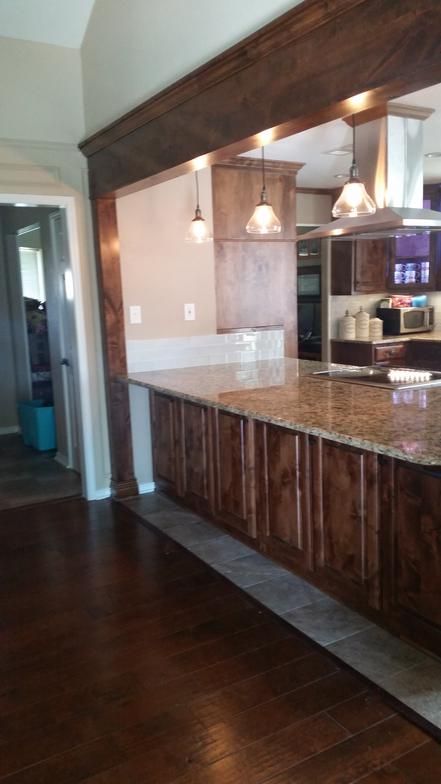 Kitchen with brown cabinets, granite countertop, and dark wood flooring.
