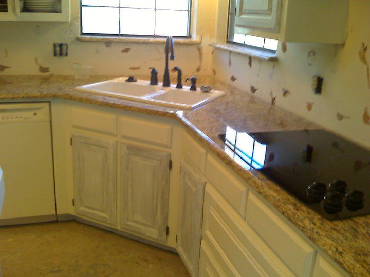 Kitchen with white cabinets, granite countertops, and a black stovetop.