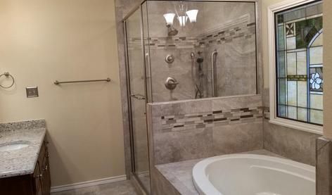 Bathroom with a glass shower, a soaking tub, and a vanity with a granite countertop.