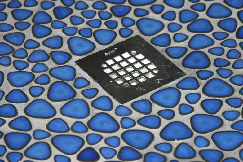 Blue pebble-patterned floor with a square drain cover in the center.