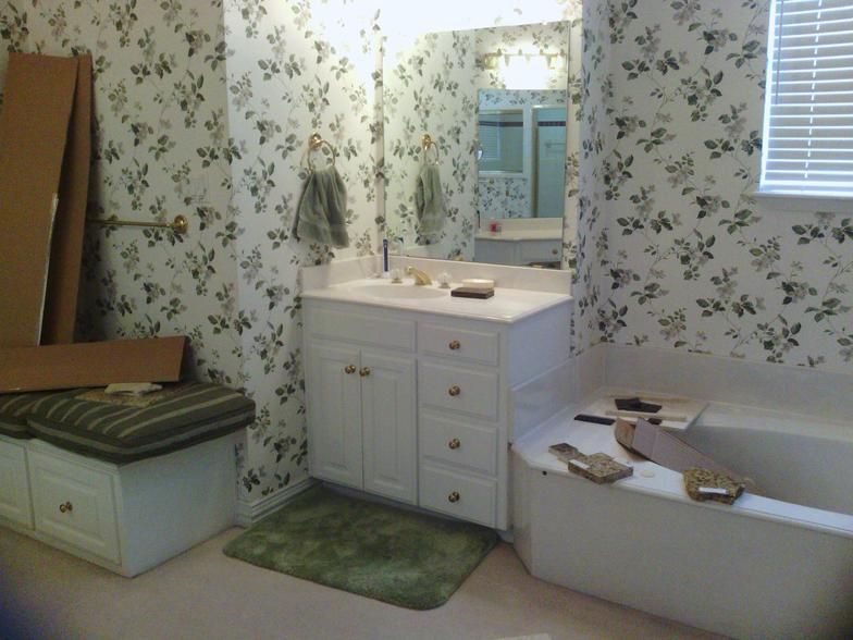 Bathroom with floral wallpaper, white vanity, and built-in bench.