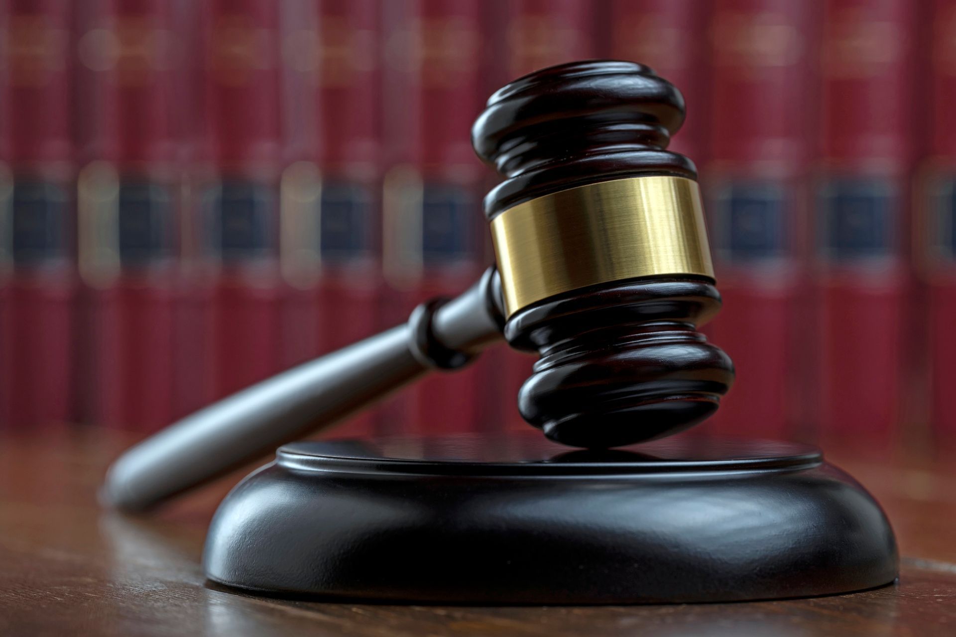 a judge 's gavel is sitting on a wooden table in front of a row of books .