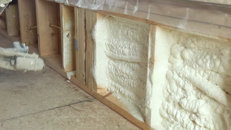 Cured spray foam insulation filling a wooden wall cavity.