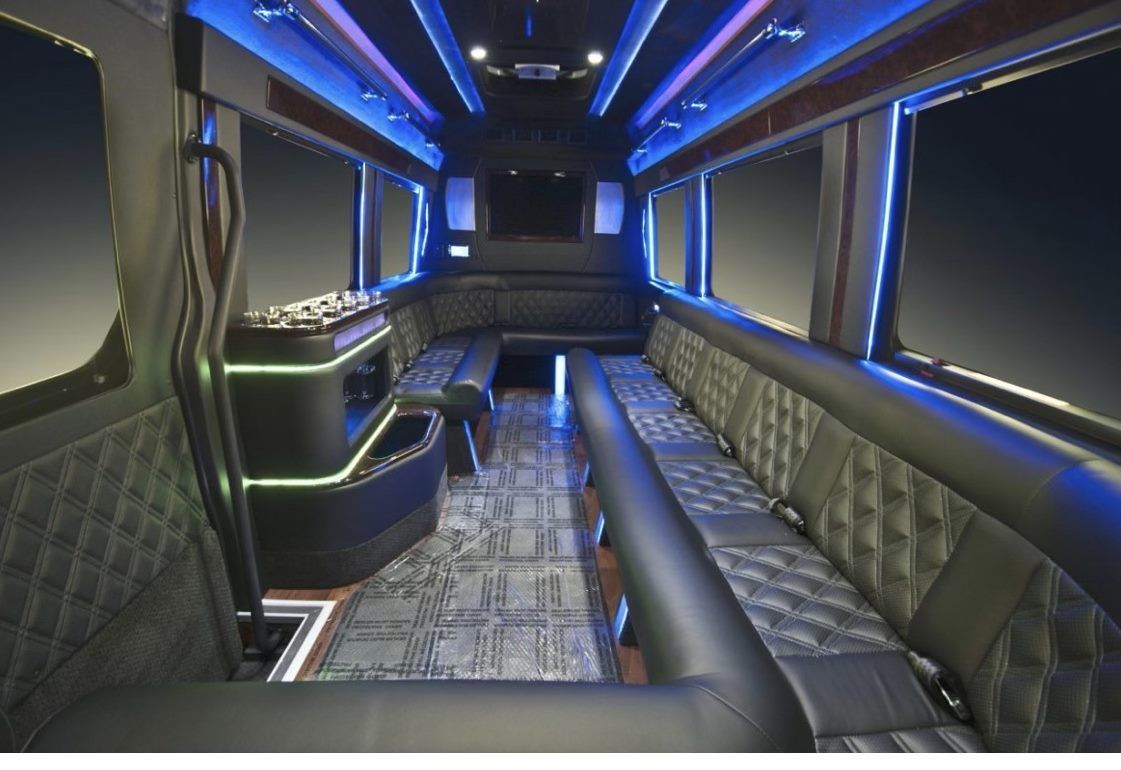 The inside of a limousine with blue lights on the ceiling.
