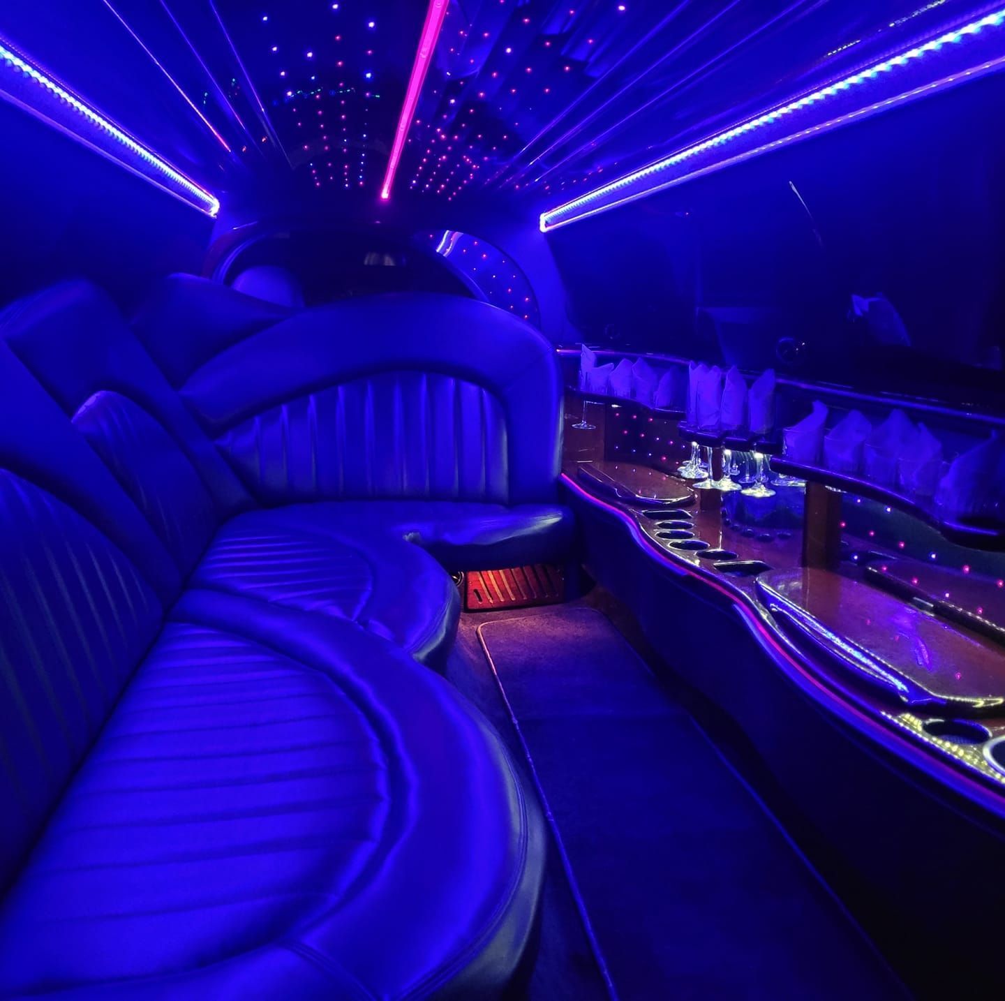 The inside of a limousine is lit up with blue lights