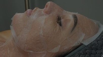 A woman is laying on a bed with a mask on her face.